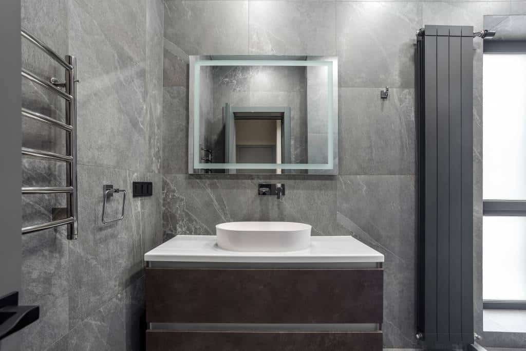 Photo de l'intérieur d'une salle de bain avec des revêtements en pierre et en béton ciré en tendance pour 2026