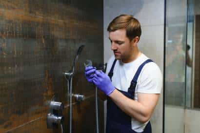 Photo d'un plombier à Rouen en train de faire une intervention dans une douche à l'italienne